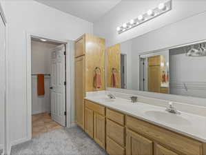 Full bathroom with double vanity and light colored carpet
