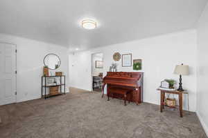 Living area with baseboards and carpet