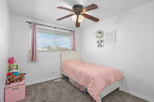 Bedroom with dark carpet and ceiling fan