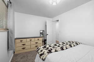 Bedroom featuring carpet and baseboards
