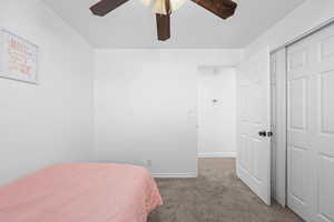 Bedroom with dark carpet and a ceiling fan