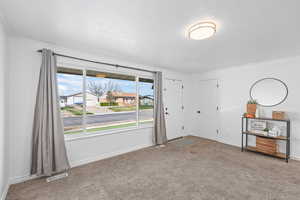 Entrance foyer with carpet floors and a textured ceiling