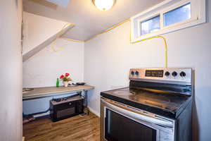 Kitchen with stainless steel electric stove, a textured ceiling, dark wood-style floors, and black microwave