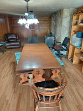 Dining area with light wood finished floors and hanging lights