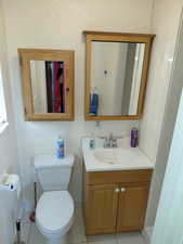 Primary bedroom's bathroom with vanity and light tile patterned floors