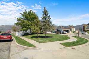 View of front of house with a mountain view and a front lawn