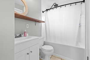 Bathroom with vanity, shower / bathtub combination with curtain, and light tile patterned flooring