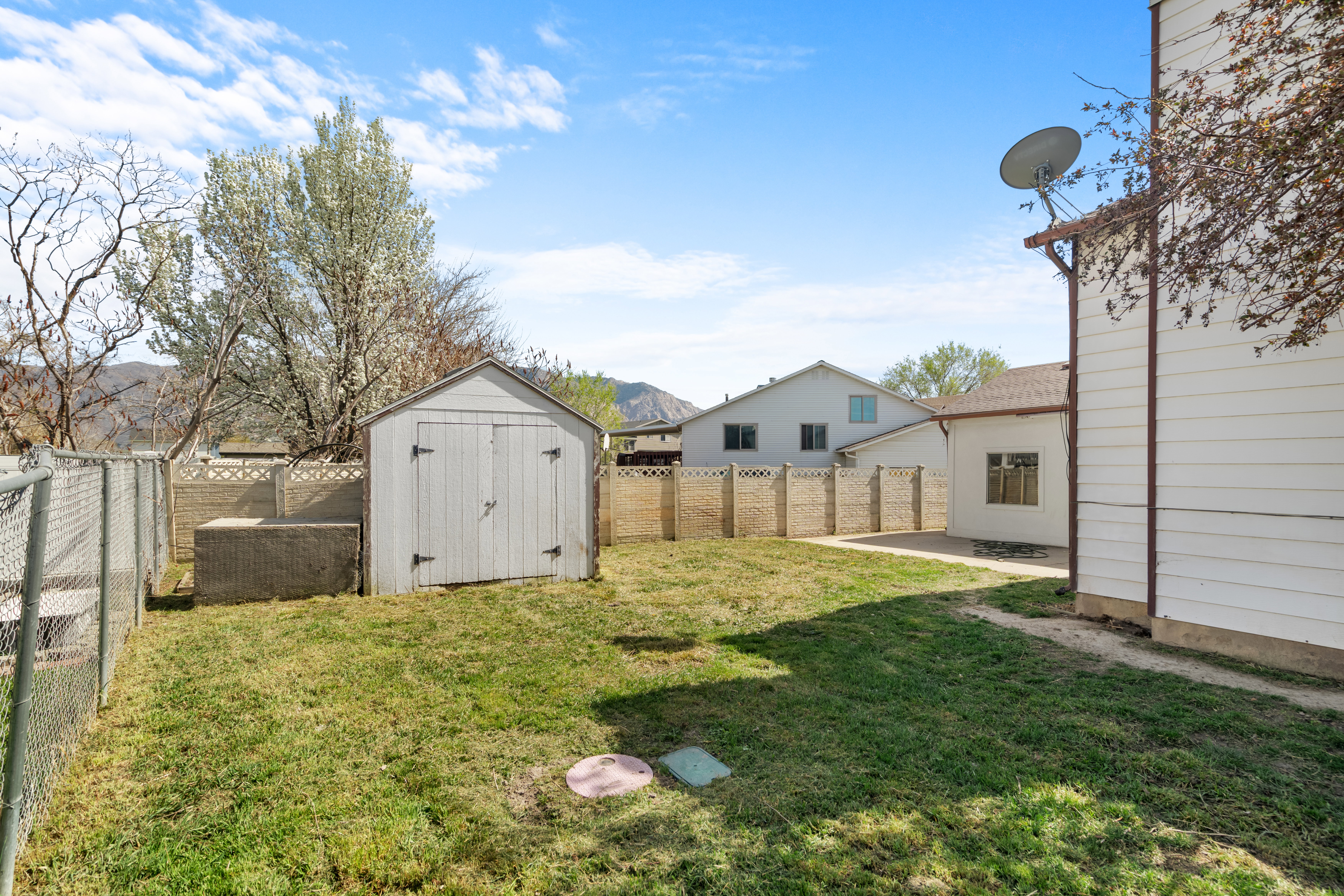 Fenced backyard featuring a shed and a patio area