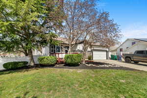 View of front of property with driveway, a garage, and stone siding