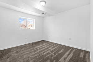 Empty room with dark carpet and baseboards