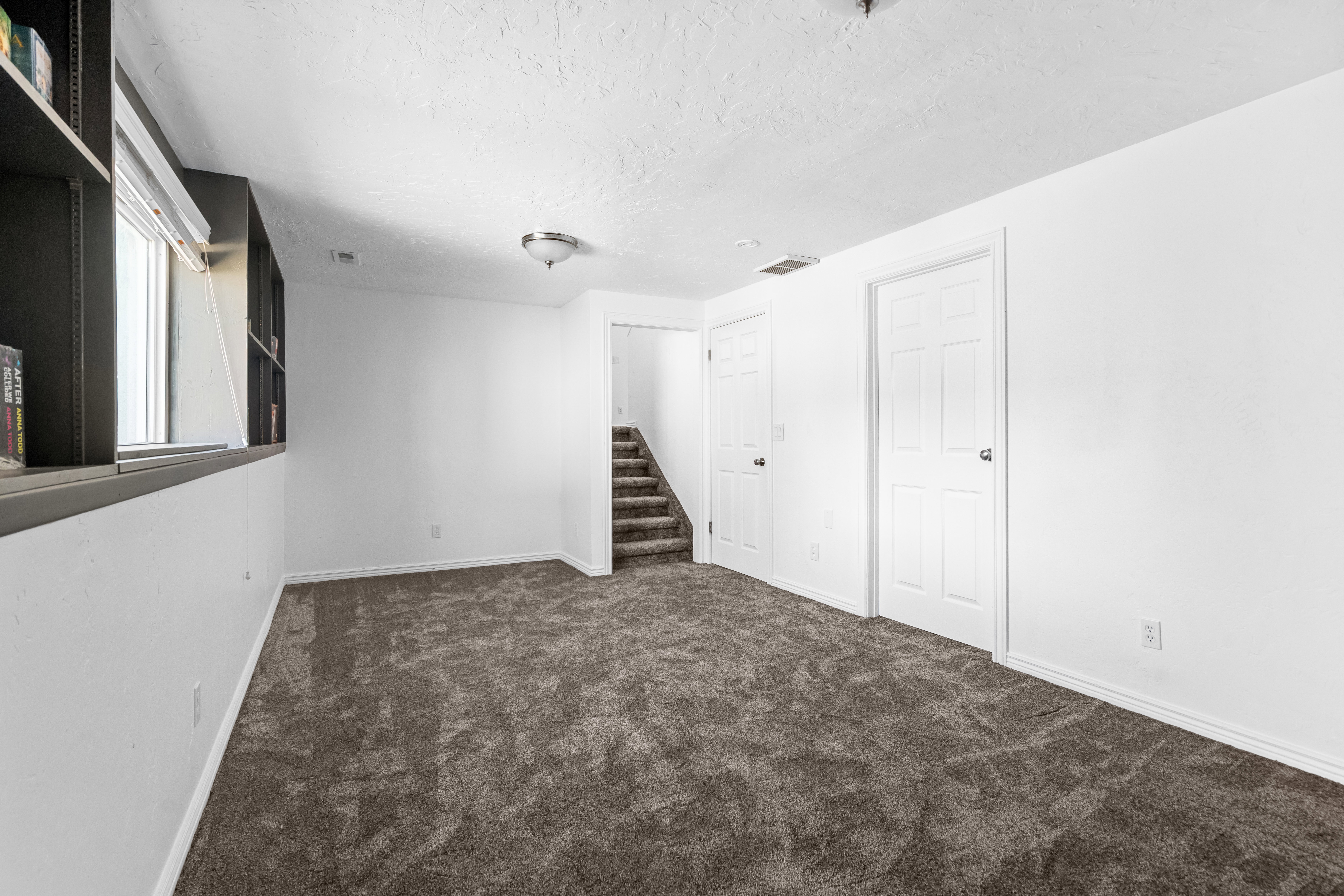 Basement featuring dark colored carpet and a textured ceiling