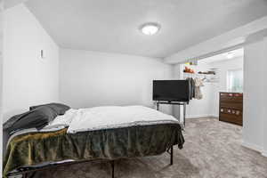 Bedroom with light colored carpet and a closet