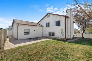 Back of house with a fenced backyard, a patio area, and a chimney