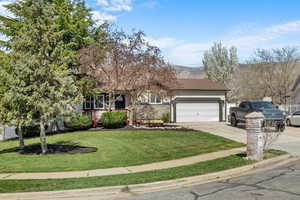 Obstructed view of property featuring driveway, a garage, a porch, a front lawn, and stucco siding