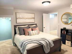 Bedroom 4 in the basement with a large closet and a friendly play nook in teal paint. Carpeted bedroom enhanced staged photo