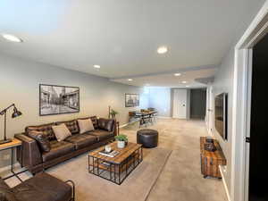 Living room with recessed lighting and newer carpet. multiple uses. Enhanced staged photo
