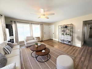Living room featuring LVP wood finished floors and ceiling fan, neutral colors - enhanced photo staged