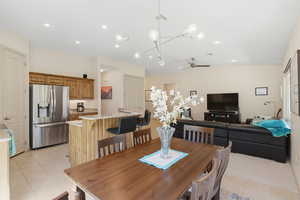 Dining area featuring ceiling fan, light tile patterned flooring, recessed lighting, and vaulted ceiling