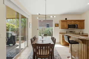 Dining room with suspended lighting and light tile patterned floors