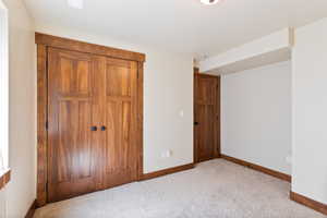 Unfurnished bedroom featuring a closet and light carpet