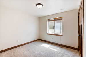 Unfurnished room with baseboards and light carpet