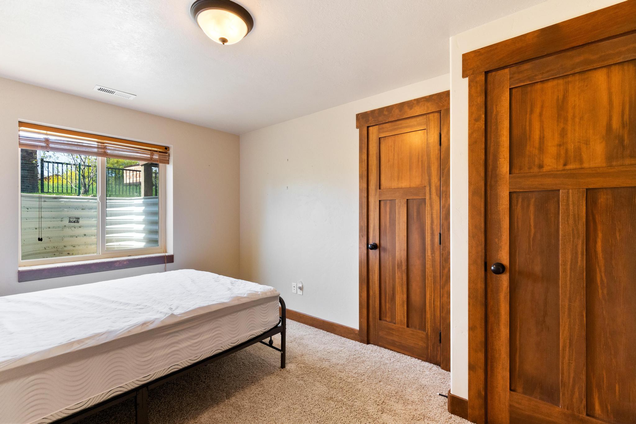 Bedroom featuring light colored carpet and baseboards