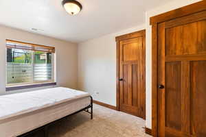 Bedroom featuring light colored carpet and baseboards