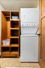 Laundry area with stacked washer and dryer and a textured ceiling