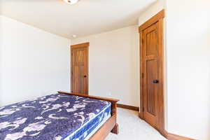 Bedroom featuring light carpet and baseboards