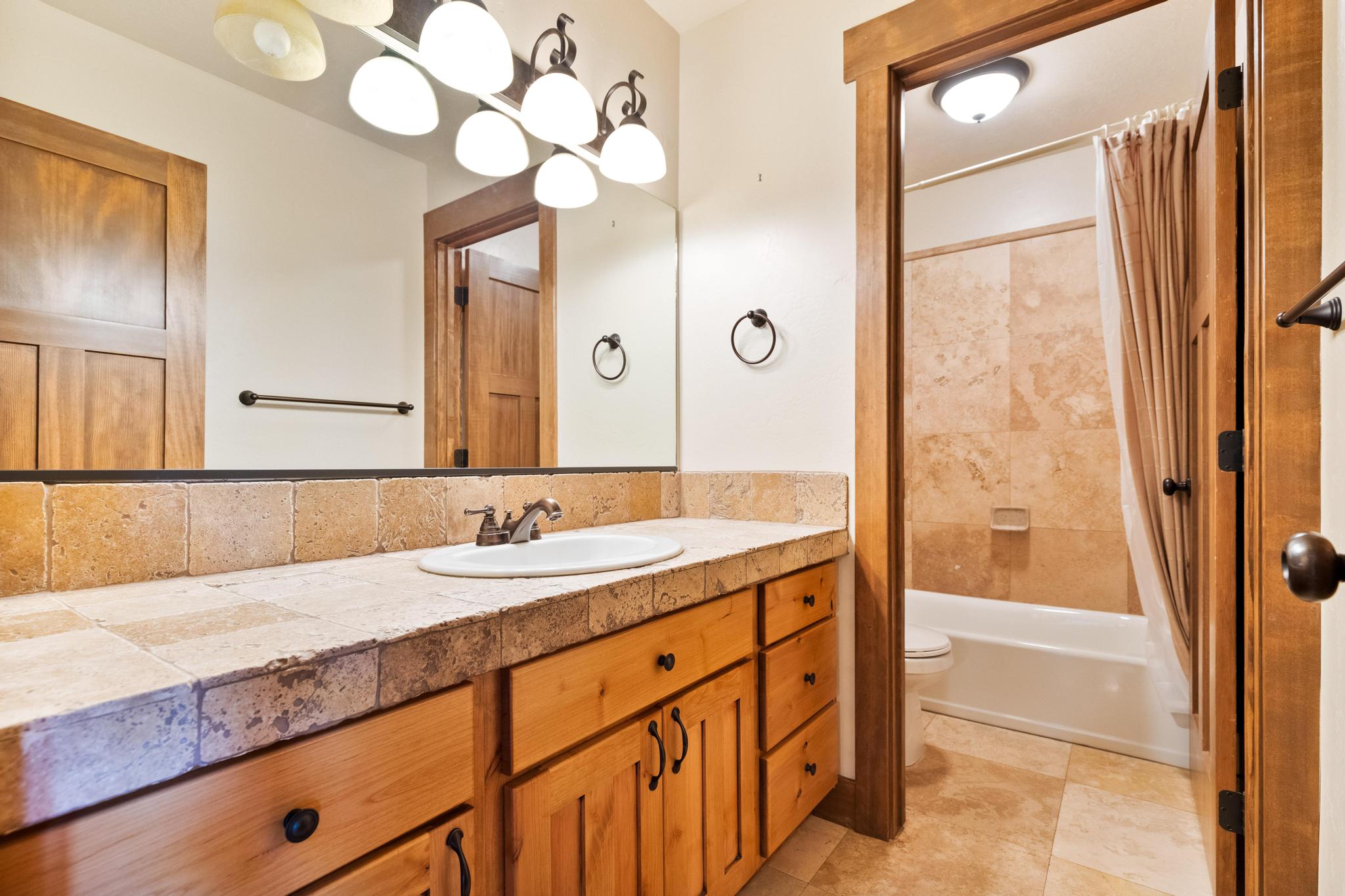 Bathroom with vanity, shower / tub combo, and light tile patterned floors
