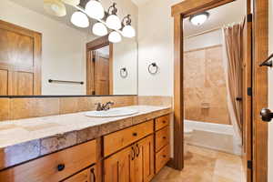 Bathroom with vanity, shower / tub combo, and light tile patterned floors