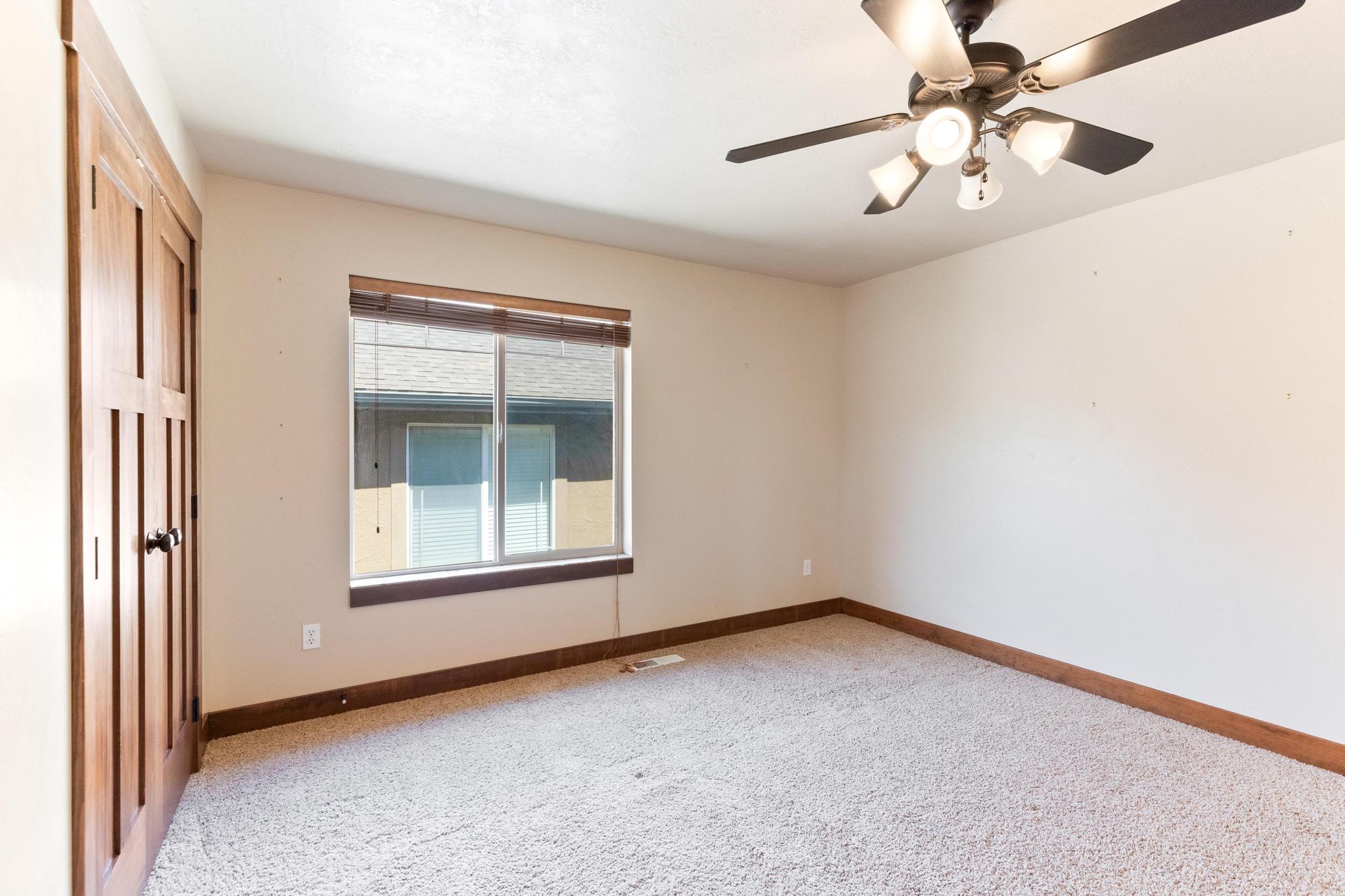Spare room featuring light colored carpet and ceiling fan