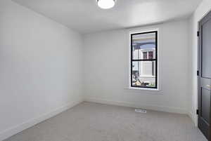Spare room with light carpet and a textured ceiling