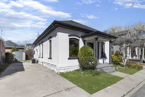View of front of house with a storage unit, stucco siding, and a front yard