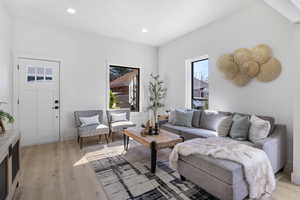 Living area with light wood-type flooring and recessed lighting