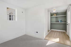 Unfurnished room featuring plenty of natural light, light colored carpet, and built in features