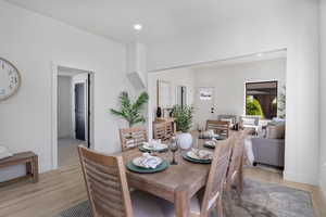 Dining area with light wood finished floors and recessed lighting