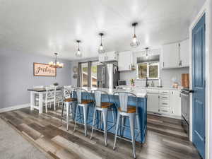 Kitchen with two tone cabinets, a kitchen bar, a center island, stainless steel appliances, and backsplash