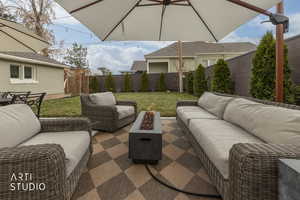 Fenced backyard with an outdoor living space with a fire pit and a patio