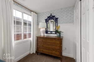 Detailed view of wallpapered walls and carpet flooring