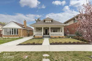 Bungalow-style house with roof with shingles, a front lawn, and covered porch