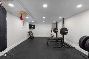Exercise room featuring dark flooring and recessed lighting