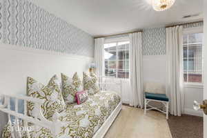 Carpeted bedroom featuring wallpapered walls and baseboards