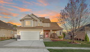 Craftsman-style home featuring an attached garage, covered porch, concrete driveway, stone siding, and roof with shingles