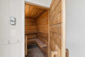Sauna / steam room with wood walls, wood ceiling, and concrete floors