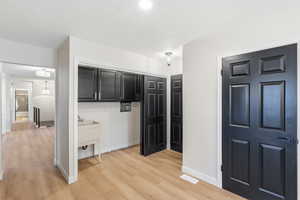 Corridor with light wood-type flooring and baseboards