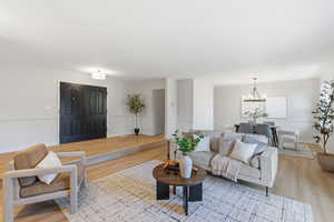 Living room featuring light wood-style flooring and suspended lighting