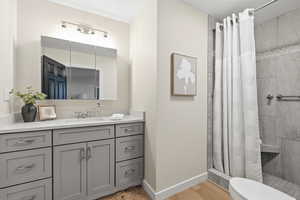 Bathroom featuring vanity, a stall shower, and light wood-type flooring