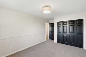 Unfurnished bedroom with carpet flooring and a closet