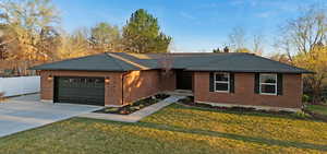 Single story home featuring concrete driveway, a garage, brick siding, and a shingled roof
